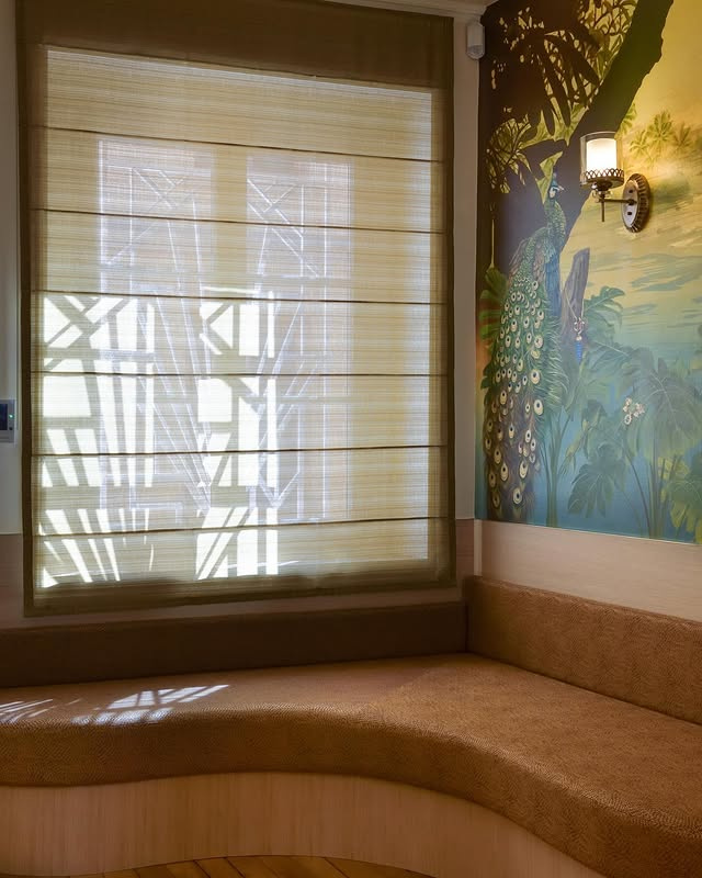 Alcôve avec banquette sur mesure, store tissé et fresque murale au paon